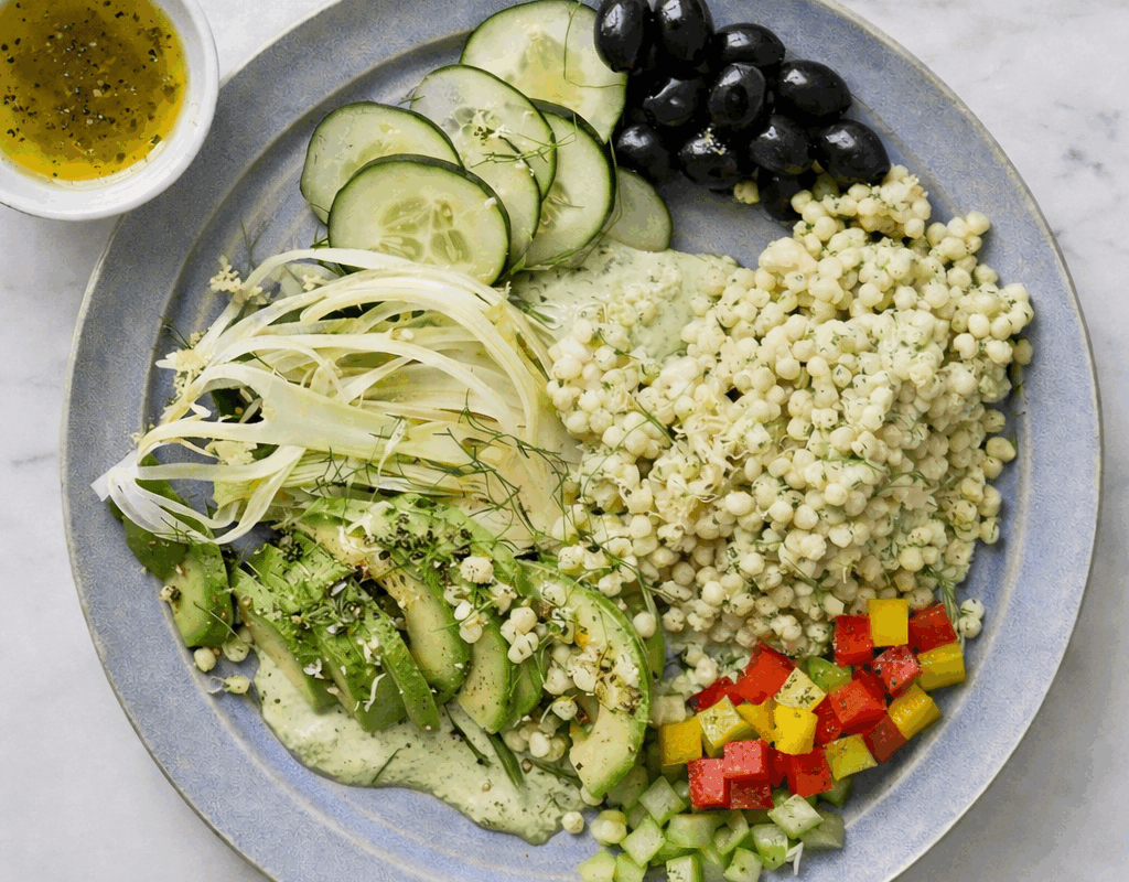 Couscous con avocado, cetrioli, peperoni, sedano e olive nere servito su piatto con vinaigrette