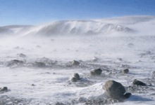 Paesaggio desolato dell’Antartide Orientale con vento intenso, ghiaccio e rocce in una delle regioni più incontaminate e inaccessibili della Terra