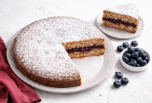 Torta di grano saraceno senza glutine con farcitura di marmellata di mirtilli su piano chiaro con mirtilli freschi