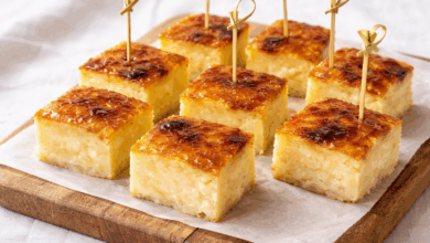 Torta di riso vegana senza uova, latte e burro con crosta caramellata, tagliata a quadratini su tagliere di legno