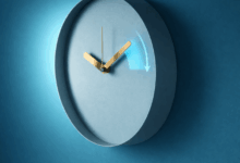 Orologio analogico minimal con freccia azzurra che indica il passaggio all’ora legale