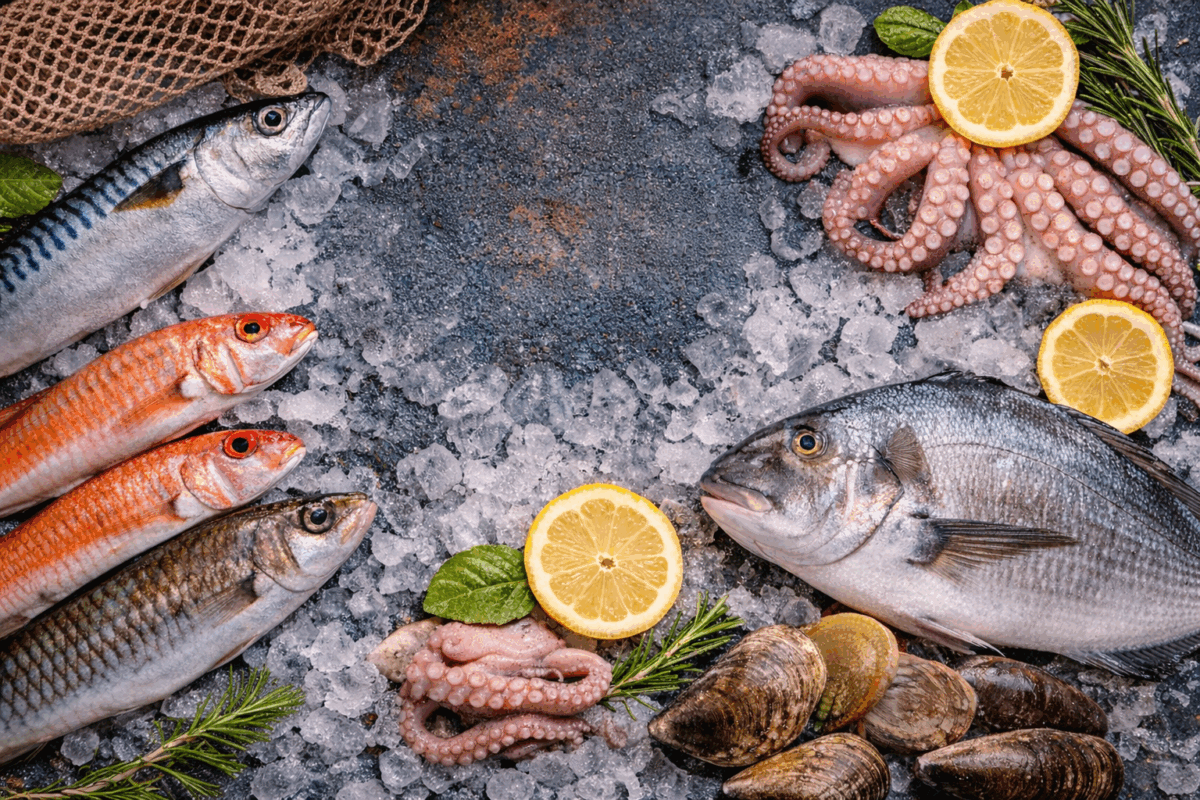 Pesce fresco su ghiaccio con sardine, triglie, orata e polpo, esempio di varietà di pesce sostenibile e di stagione