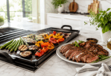 Verdure colorate che cuociono sulla piastra accanto a un piatto di carne grigliata su piano in marmo bianco in una cucina elegante e luminosa