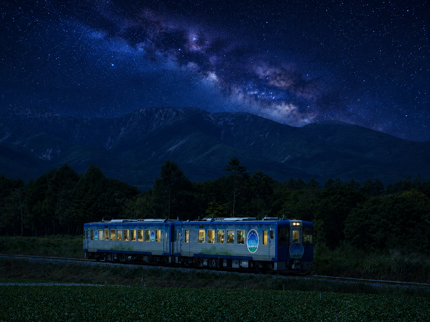 Il treno giapponese High Rail 1375 fermo sulle montagne della zona di Koumi, sotto un cielo stellato con Via Lattea visibile, durante la sosta per osservare le stelle