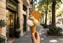 Cono gelato davanti a una gelateria in una strada elegante e alberata, immagine usata per illustrare i trucchi per scegliere il gelato meno calorico al banco