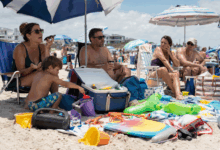 Famiglia rumorosa in spiaggia con giochi, borse, cibo e attrezzature che invadono lo spazio dei bagnanti vicini