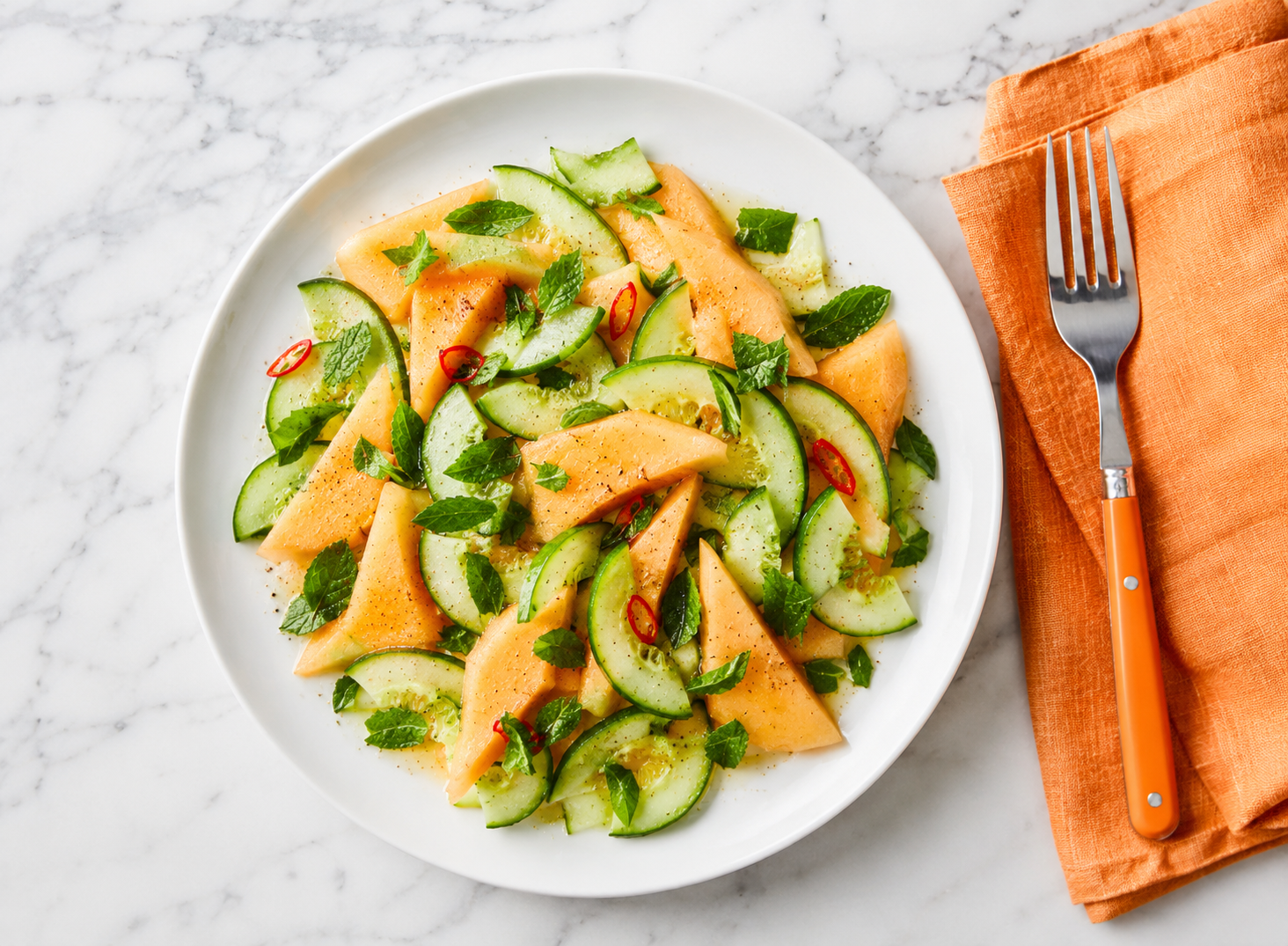 Carpaccio di melone e cetrioli con erbe aromatiche, servito su piatto bianco con acqua ghiacciata e olio, ricetta fresca, veloce e leggera